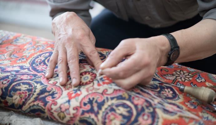 a professional performing maintenance on a rug