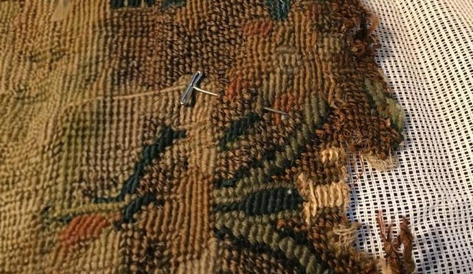 A tapestry undergoing repair